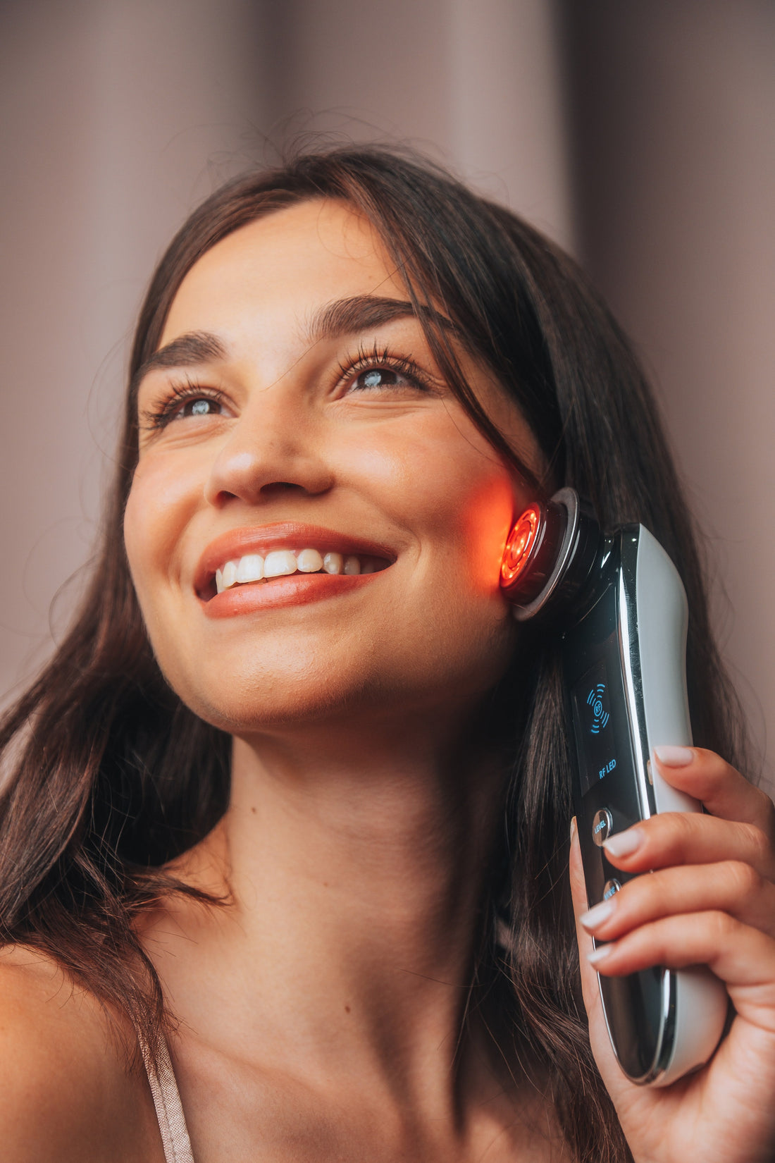 Woman using the Lunerra wand with red LED light on her cheek